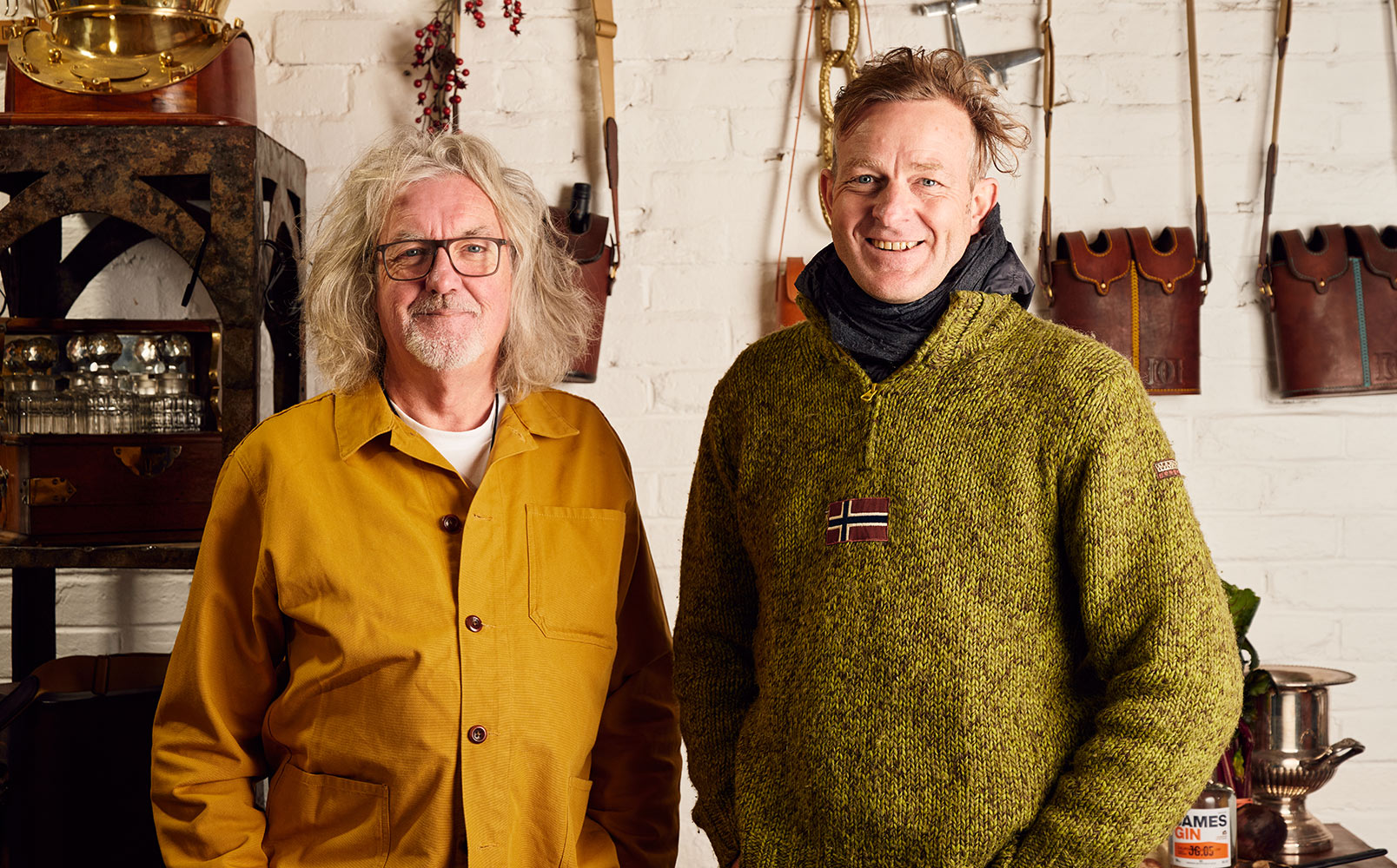 James May and Hugh standing side by side in the shed surrounded by tools and shelves with glassware and tools