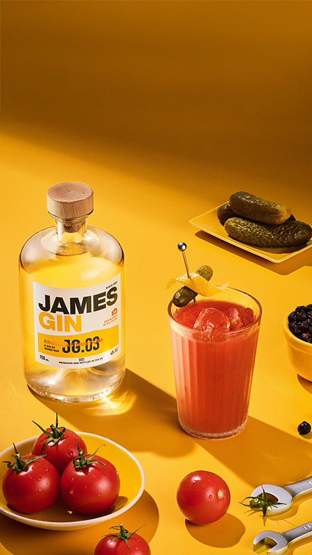 James Gin American Mustard bottle with a cocktail and garnishes on a yellow background. Award winning gin by James May.