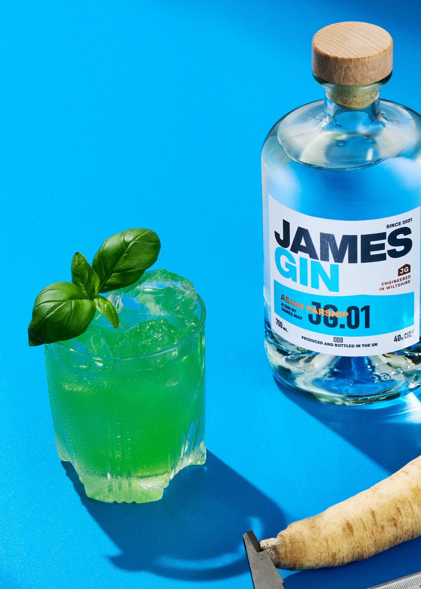 A bottle of James gin, asian parsnip alongside a green cocktail and a parsnip being measured by a calipers